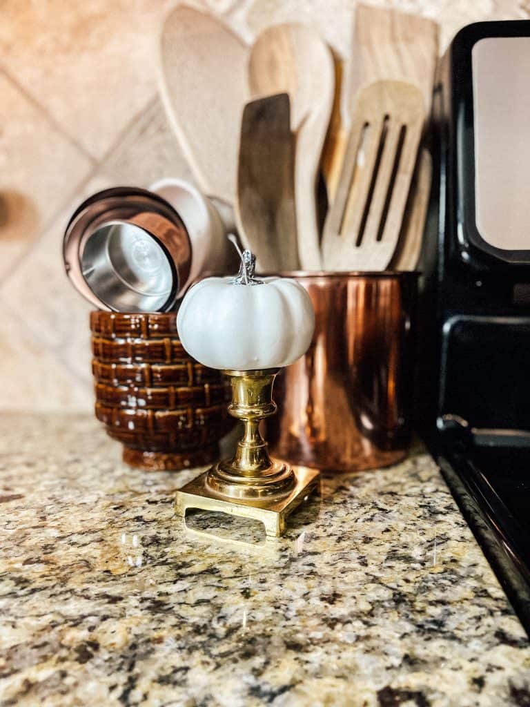 vintage brass candlesticks with kitchen utensils