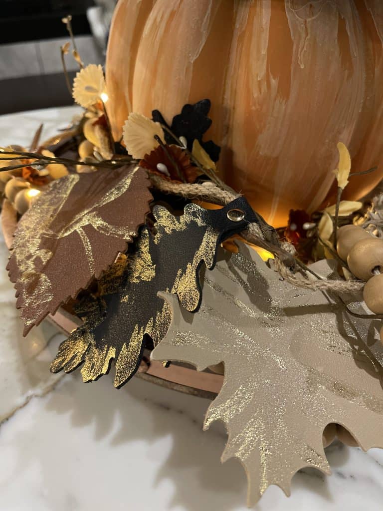 gold foil leaves around a terra cotta pumpkin