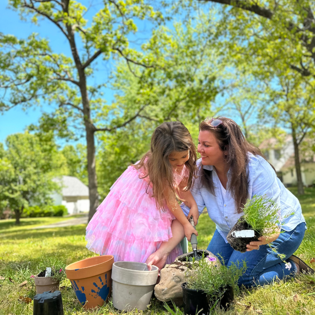 little girl and her mom planting flowers