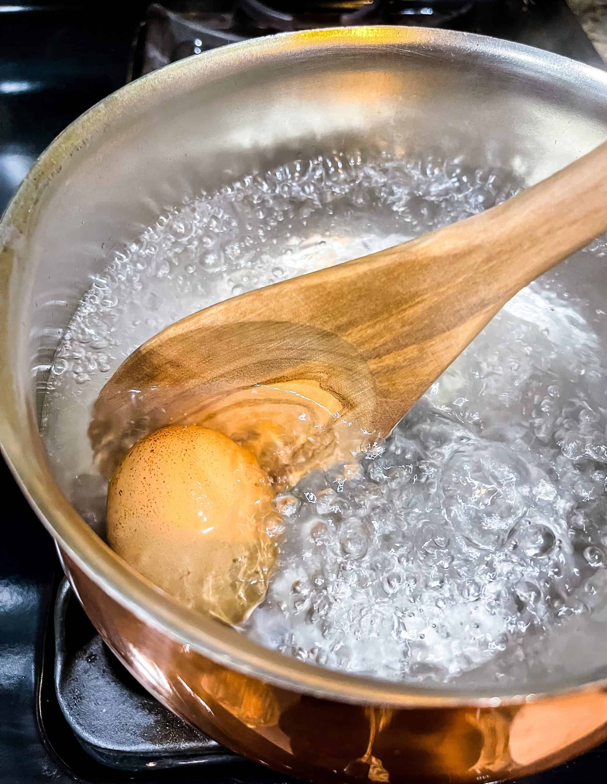 adding an egg to boiling water