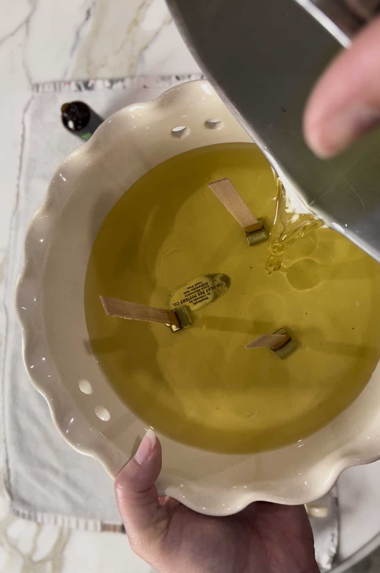 Pouring citronella scented wax into a vintage vessel
