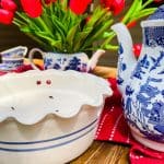 citronella candle with blue and white teapots and red tulips