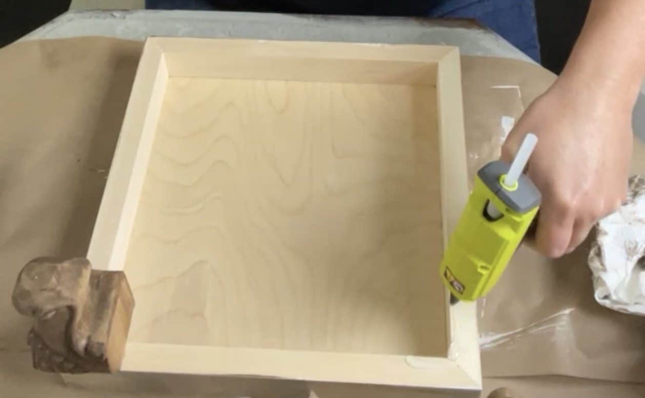 Hot glue the furniture feet on the wood panel