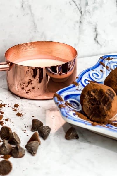 Blue and White dish with copper measuring cup and homemade truffles sitting with a bite out
