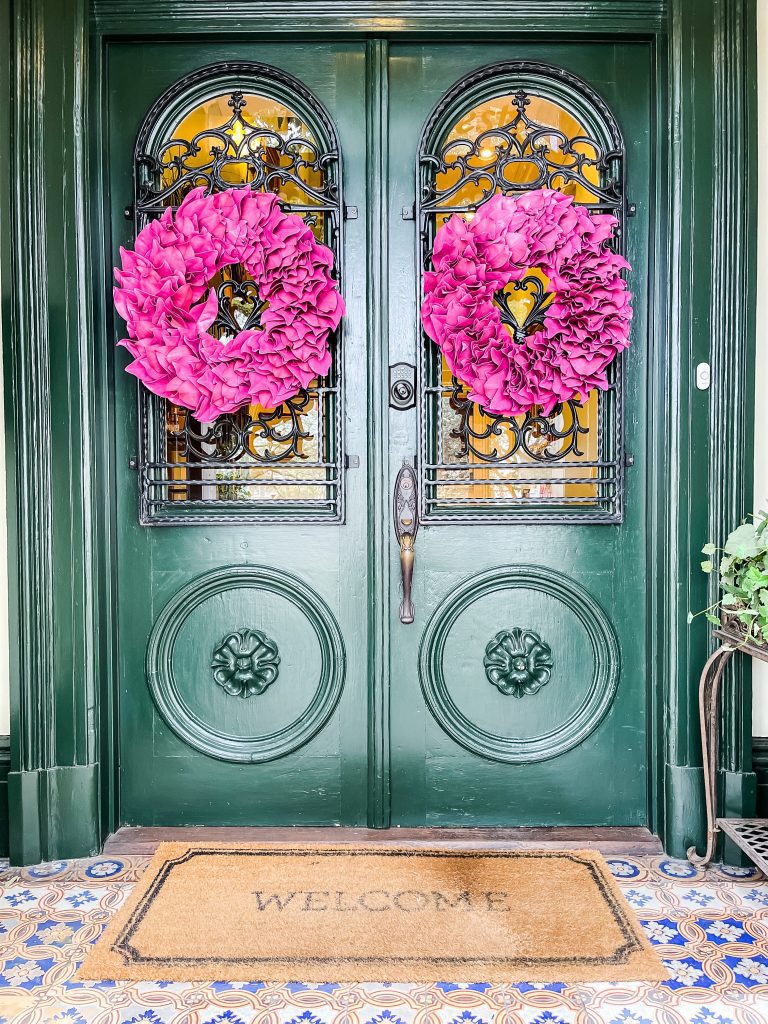 double green glass entry doors with fuscia wreaths